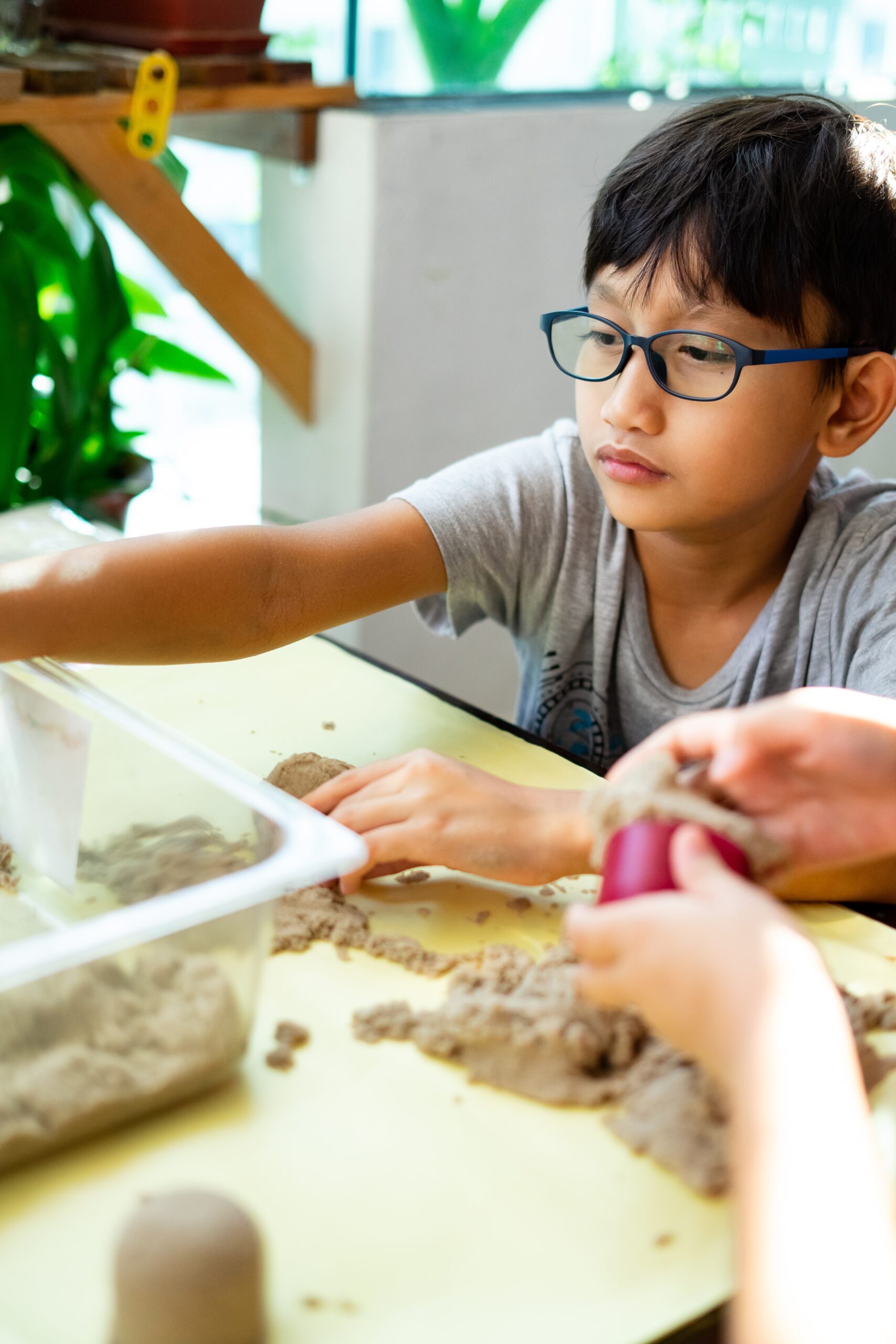 Child playing with kinetic sand at a table