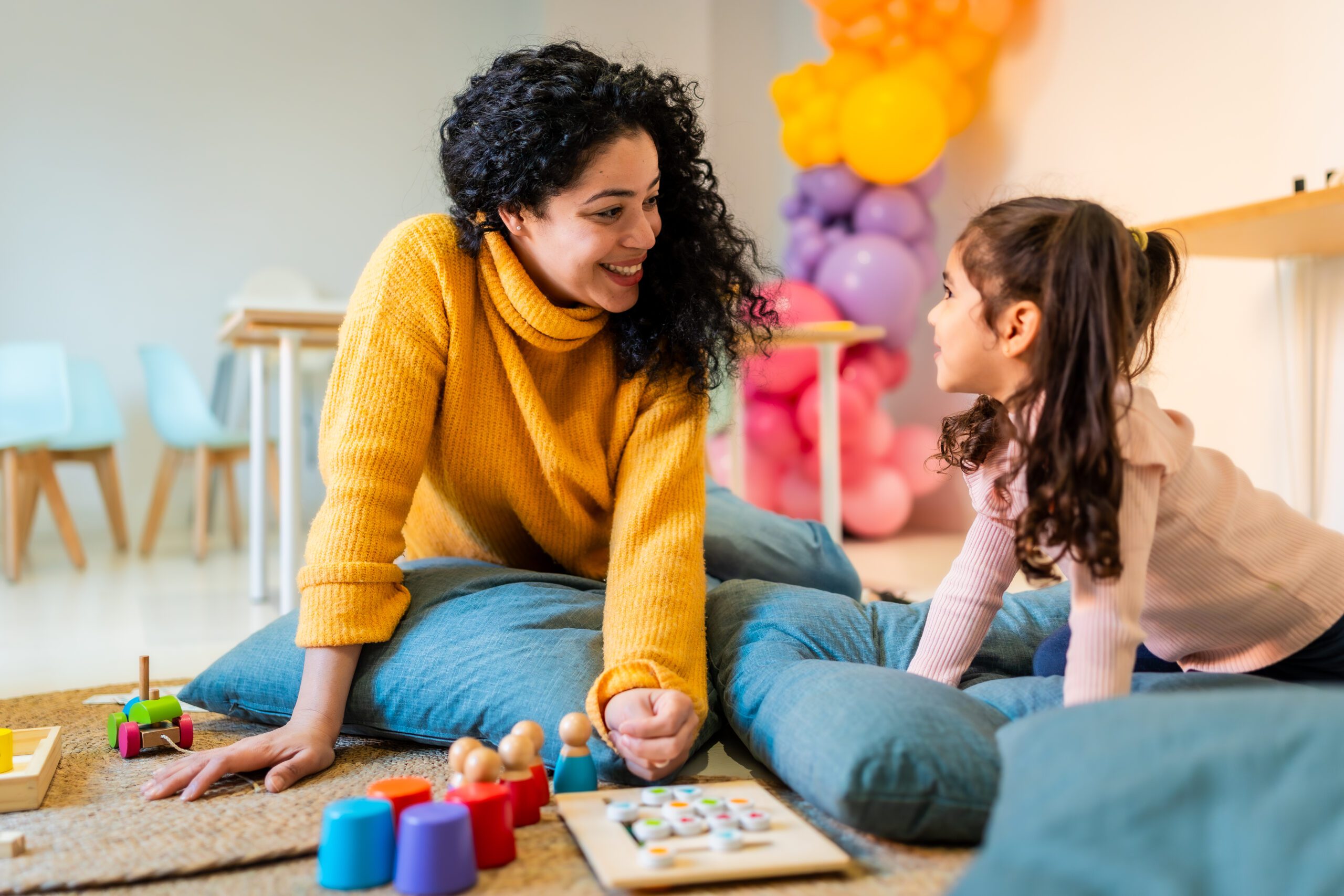 Woman and young girl playing with educational toys